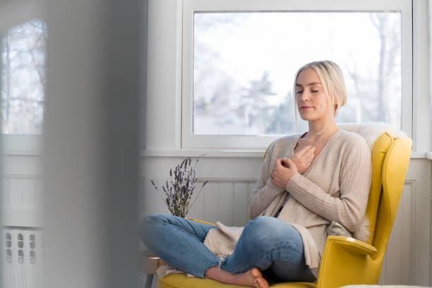 woman meditating at home - respiração - fotografias e filmes do acervo