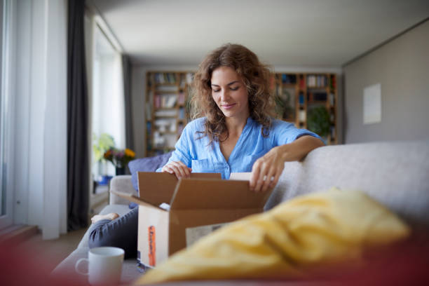 woman opening box while sitting on sofa at home picture id1284720016?k=20&m=1284720016&s=612x612&w=0&h=fJQanXDzB28FHpDVY2V sG3z3RmFaXnBbPdy6I7NP8=