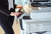 Woman pressing button on a copy machine in the office