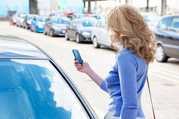 Woman reading text near line of cars
