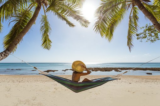 woman relaxing on hammock under palm tree on a tropical beach fiji picture