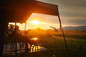 Woman rests after safari in luxury tent during sunset camping in African savannah of Serengeti National Park,Tanzania.