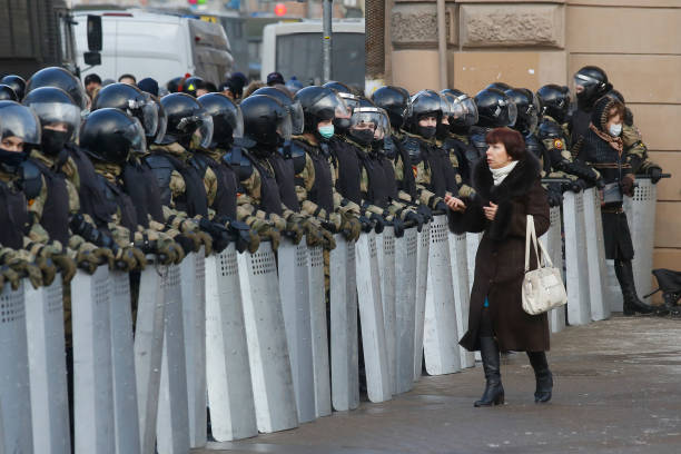 Woman walks in front of national guard officers during the demonstration. Protest against the detention of the opposition leader Alexey Navalny in...