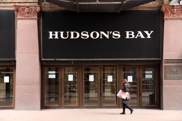 woman wearing a face mask walks past a hudsons bay co flagship store picture