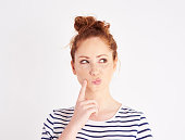 Woman with hand on chin thinking at studio shot