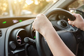 Woman's hands on car steering wheel