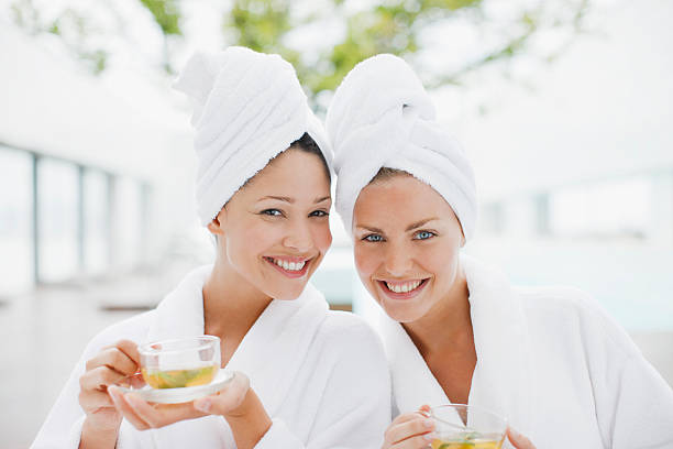 Women in bathrobes drinking tea at spa