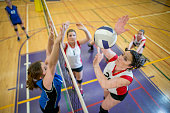 Women Spiking and Blocking a Volleyball