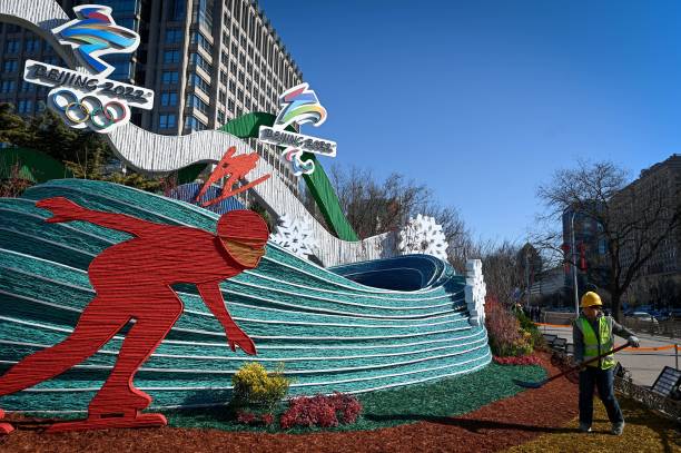 Worker decorates installations of Beijing 2022 Winter Olympic Games and Beijing 2022 Winter Paralympic Games along a street in Beijing on January 17,...