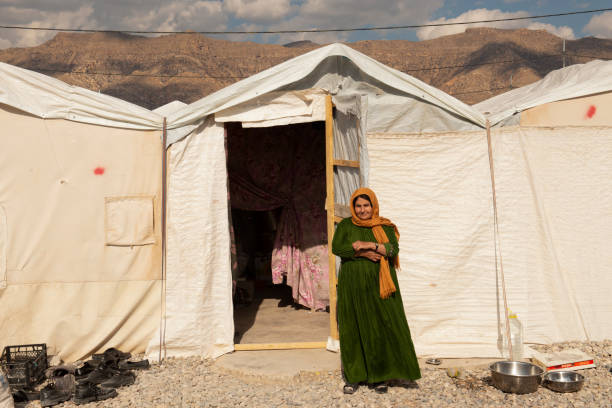Yazidi woman stands in front of her tent in Bersive Camp near Zakho in Iraq.