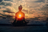 Yoga day concept. Multiple exposure image. Clouds and sun. Pranayama in lotus asana.