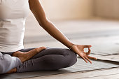 Yogi black woman practicing yoga lesson, doing Ardha Padmasana exercise