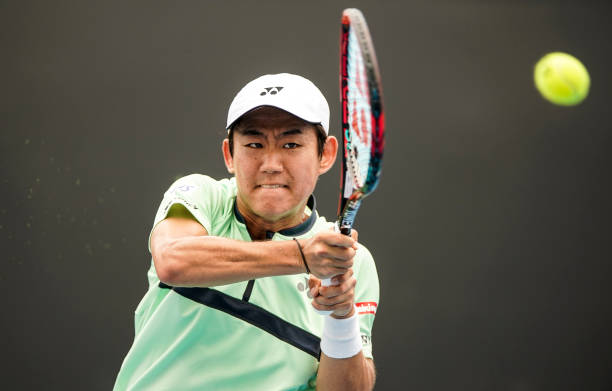 Yoshihito Nishioka of Japan plays a backhand in his first round match against Philipp Kohlschreiber of Germany on day one of the 2018 Australian Open...