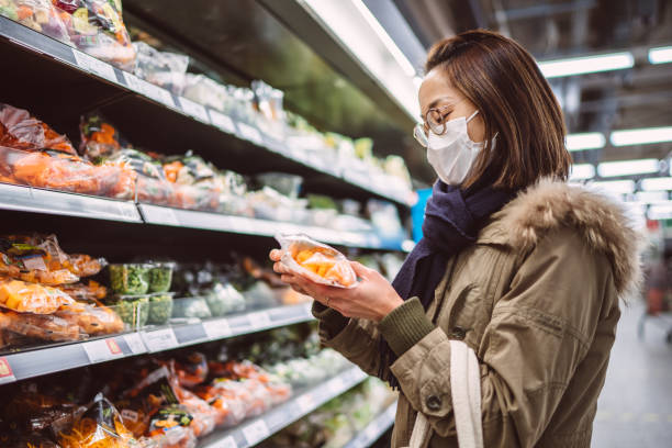 young asian woman in protective face mask doing grocery shopping for picture