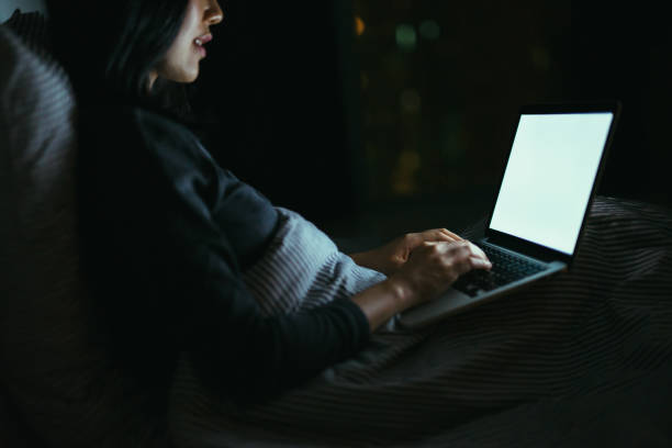 young asian woman lying on bed using laptop at night - seo - fotografias e filmes do acervo