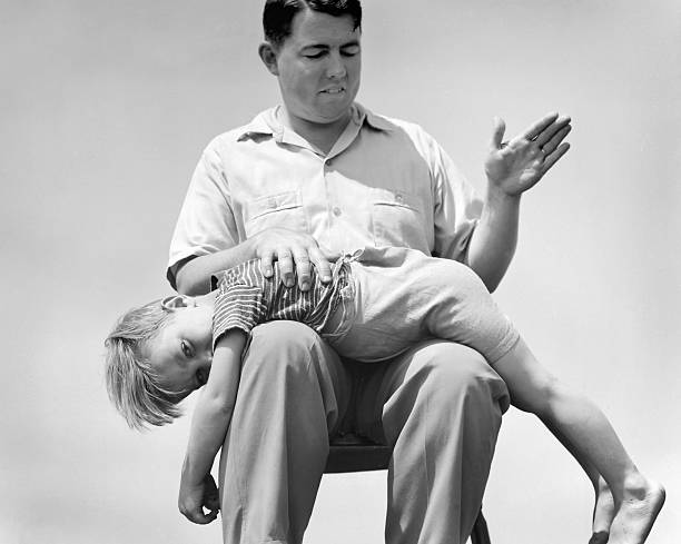 young-boy-receives-a-spanking-from-his-father-in-this-staged-picture-id526621144