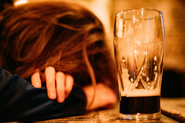 young drunk woman sleeping on bar counter drinking dark beer - drunk woman stock pictures, royalty-free photos & images
