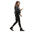 Young female walking and looking at her mobile phone