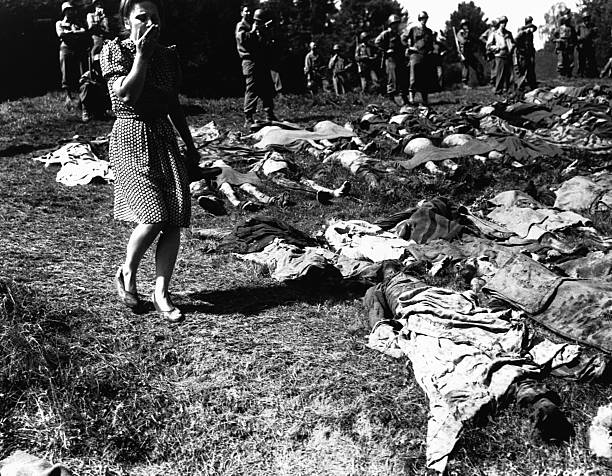A young German woman is overcome as she walks past the exhumed bodies of some 800 slave workers murdered by SS guards near Namering Germany and laid...