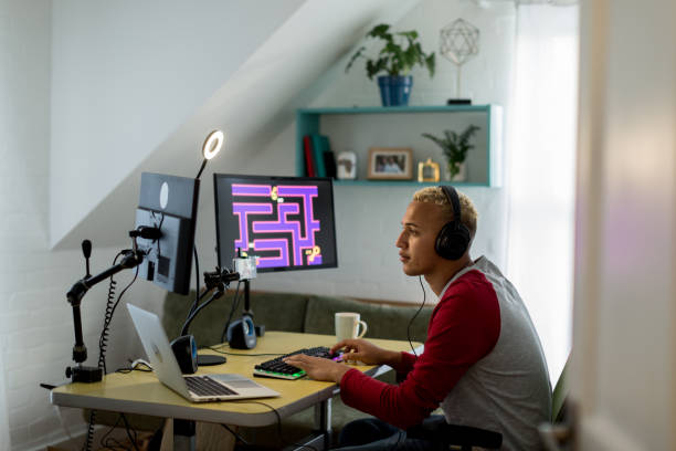 young mixed race gamer playing online in his bedroom - web developer stock pictures, royalty-free photos & images