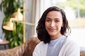 Young mixed race woman in coffee shop looking to camera