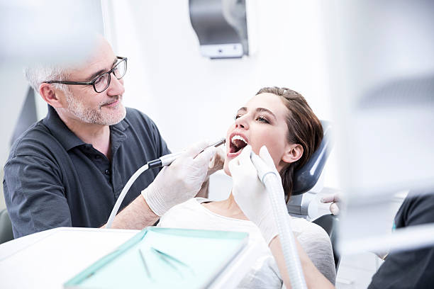 young woman getting dental treatment - odontologia - fotografias e filmes do acervo