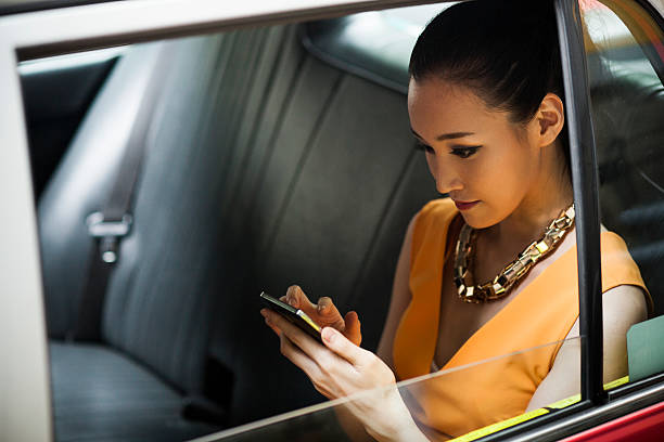 young woman in taxi - serious asian woman in the car stock pictures, royalty-free photos & images