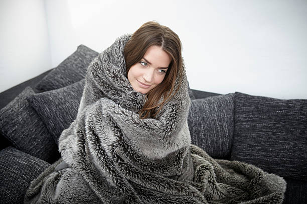 young woman on couch wrapped in fur blanket picture