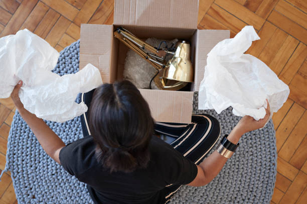young woman opening box with lamp at home picture