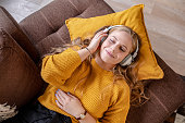 Young woman relaxing at home and listening music