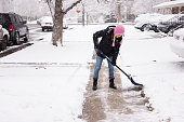 Young woman shoveling snow