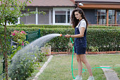 young woman watering plants country house