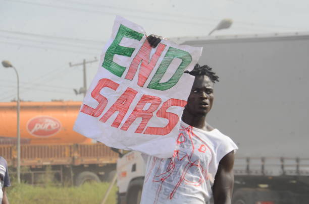 Youth of End Sars Protesters hold a placard with description to barricade the Lagos - Ibadan expressway, the oldest highway and major link to all...