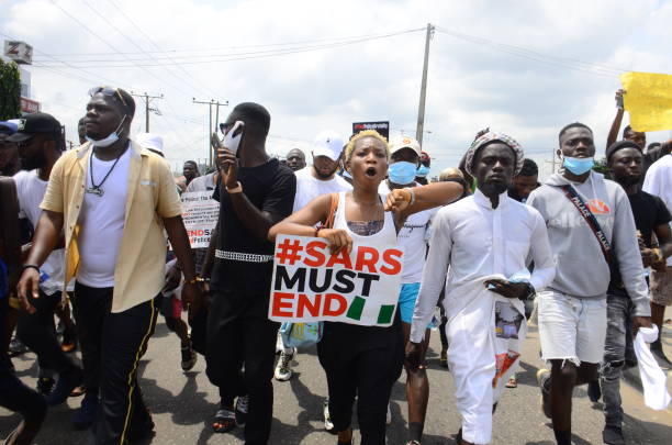 Youths of ENDSARS protesters display their placards in a crowd in support of the ongoing protest against the harassment, killings and brutality of...
