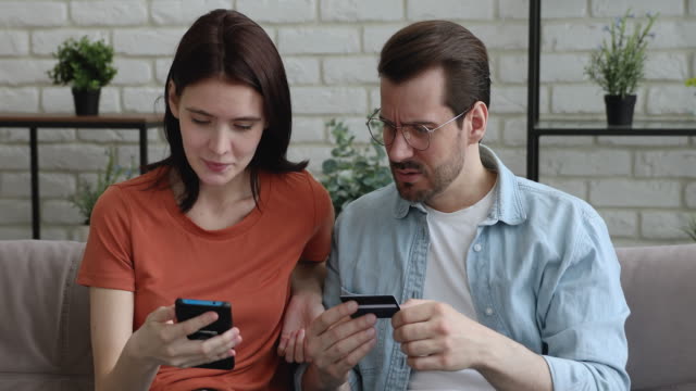 Couple using card and smartphone having problems with online payment