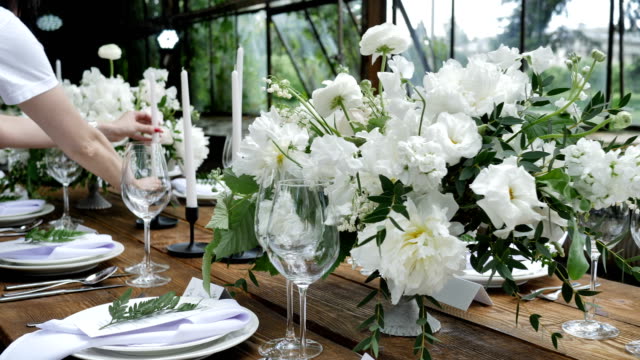 Decorating a festive table. Wedding table decoration with bouquets of Nnatural fresh flowers for a family feast