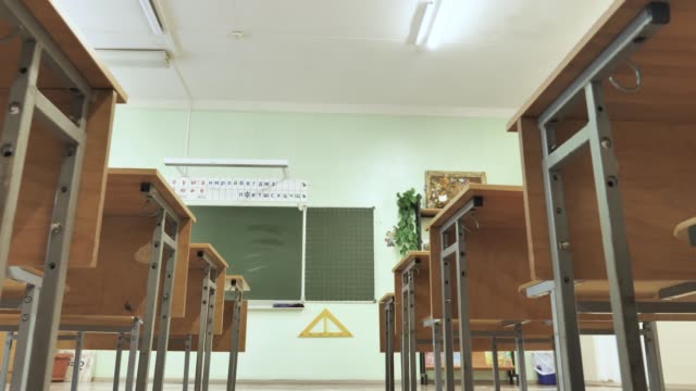 Empty Classroom with Wooden Desks and Green Chalkboard at School